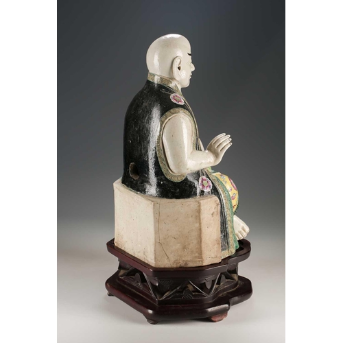 256 - A Chinese porcelain figure of a seated Luohan, Qing, 18th/19th century, his facial features, fingers... 