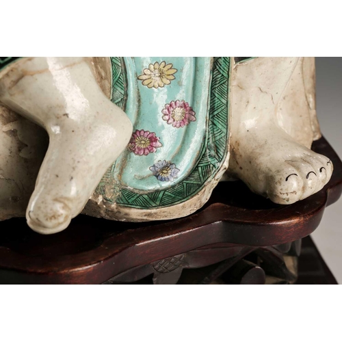 256 - A Chinese porcelain figure of a seated Luohan, Qing, 18th/19th century, his facial features, fingers... 