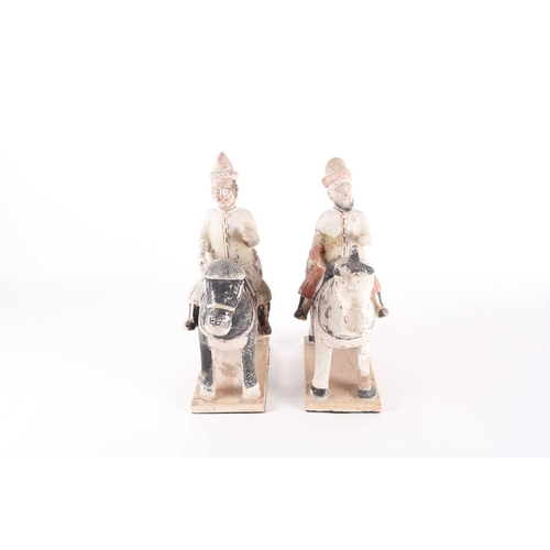 279 - A pair of Chinese equestrian funerary figures, Ming Dynasty, one painted black, the other white, the... 