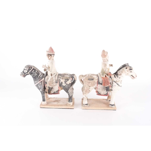 279 - A pair of Chinese equestrian funerary figures, Ming Dynasty, one painted black, the other white, the... 