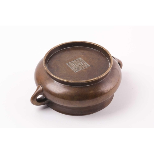 332 - A Chinese bronze censer, Qing, 18trh century, of compressed circular cushion form, with loop handles... 