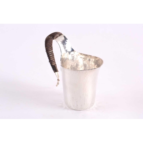 441 - A contemporary Japanese small silver jug, the s curved handle wrapped in bamboo, the planished body ... 