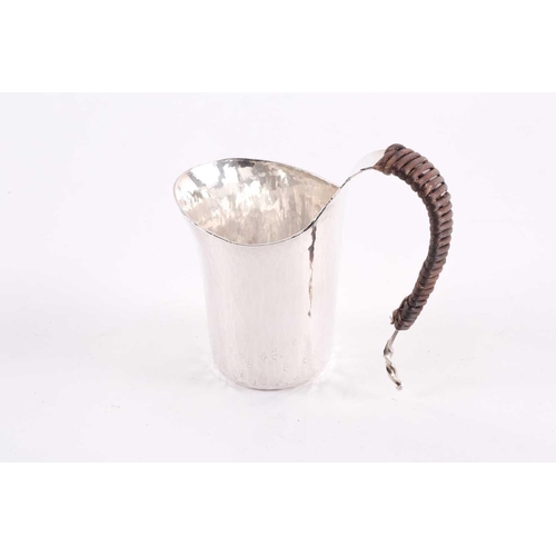 441 - A contemporary Japanese small silver jug, the s curved handle wrapped in bamboo, the planished body ... 