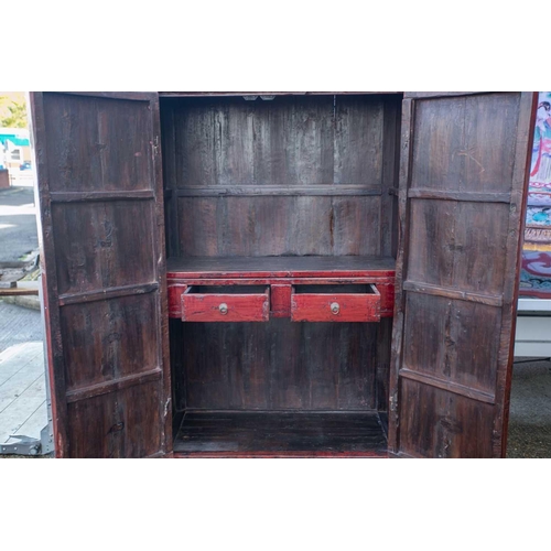 47 - A Chinese red lacquer cabinet, Qing, mid 18th century, the two doors joined by a circular escutcheon... 