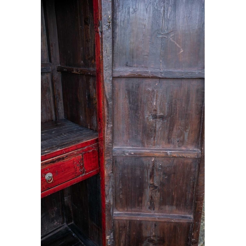 47 - A Chinese red lacquer cabinet, Qing, mid 18th century, the two doors joined by a circular escutcheon... 