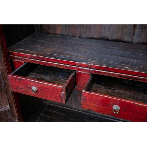 47 - A Chinese red lacquer cabinet, Qing, mid 18th century, the two doors joined by a circular escutcheon... 