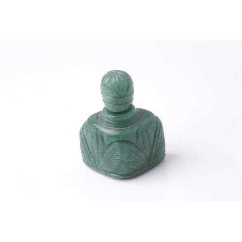 70 - An Eastern carved variegated green hardstone scent bottle of trapezoidal section with pommel carved ... 