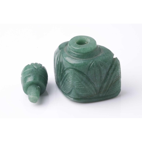 70 - An Eastern carved variegated green hardstone scent bottle of trapezoidal section with pommel carved ... 