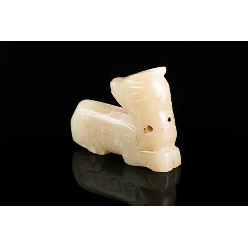 92 - A jade recumbent deer, looking back on itself, with archaic style incised decoration, pierced at the... 