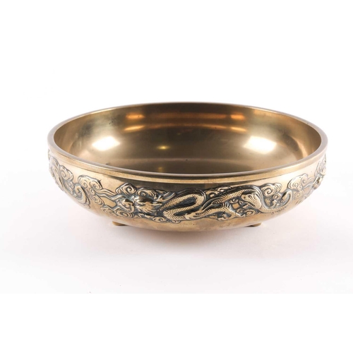 96 - A large Chinese brass double walled bowl, early 20th century, the exterior with a relief cast band o... 