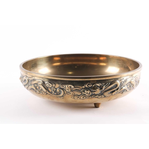 96 - A large Chinese brass double walled bowl, early 20th century, the exterior with a relief cast band o... 