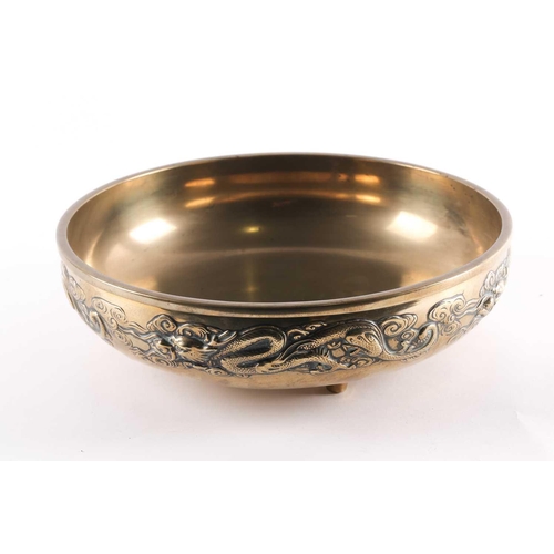 96 - A large Chinese brass double walled bowl, early 20th century, the exterior with a relief cast band o... 