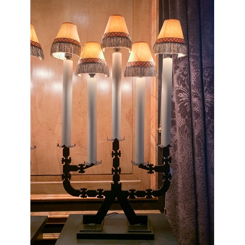 51 - A pair of 20th century five sconce black iron candelabra table lamps, each with faux candles and tas... 