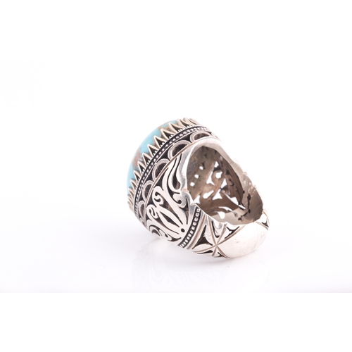 107 - A large Persian silver gentleman's ring, set with a turquoise coloured stone, a short inscription on... 