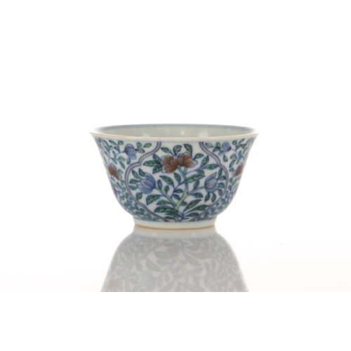 110 - A Chinese porcelain doucai tea bowl, of tapering form, painted with blossoming flowers within colour... 