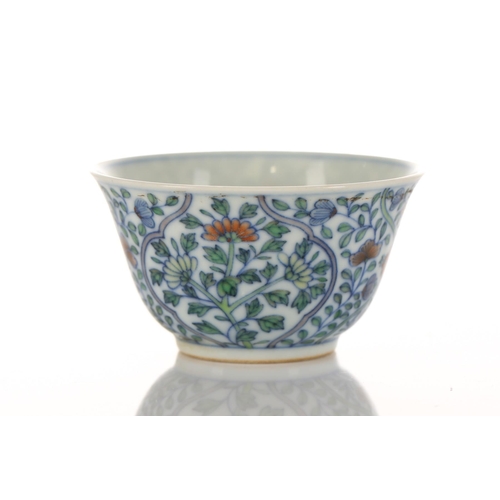 110 - A Chinese porcelain doucai tea bowl, of tapering form, painted with blossoming flowers within colour... 