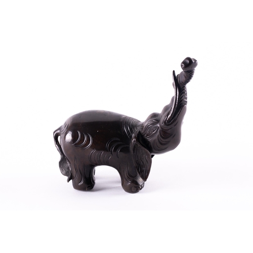 112 - A Chinese patinated bronze elephant figure of archaic form, with trunk held aloft. 765 grams. 13 cm ... 