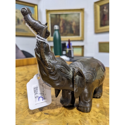 112 - A Chinese patinated bronze elephant figure of archaic form, with trunk held aloft. 765 grams. 13 cm ... 