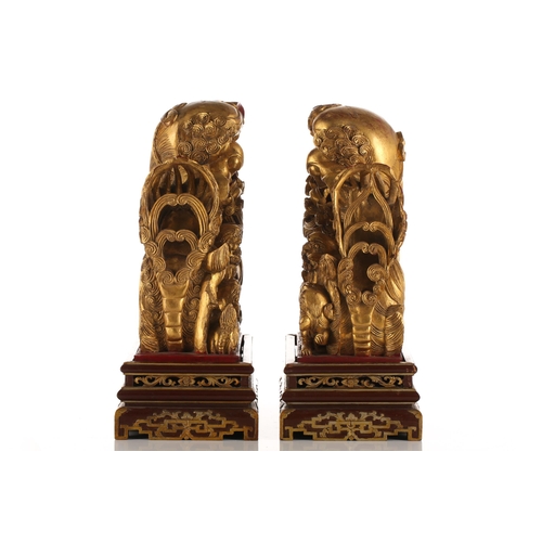 121 - A pair of Chinese carved and gilded wood temple lions and pups, each with characteristic scrolling m... 