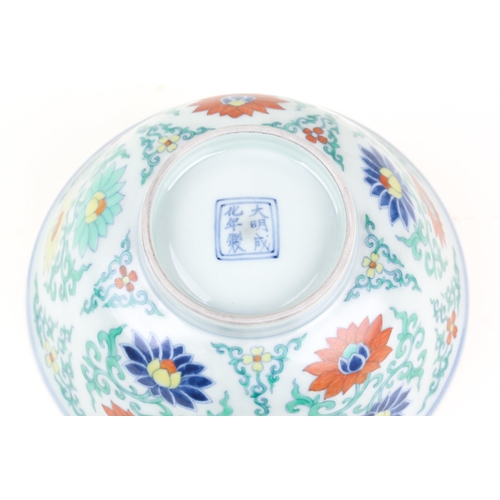 134 - A Chinese Doucai bowl, painted with blue, red & yellow lotus flowers, amongst green tendrils, apocry... 