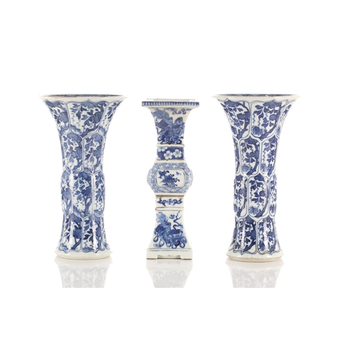 146 - A close pair of Chinese blue & white Gu vases, Qing, Kangxi period, painted with foliage in shaped p... 