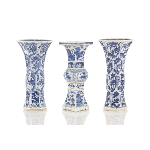 146 - A close pair of Chinese blue & white Gu vases, Qing, Kangxi period, painted with foliage in shaped p... 