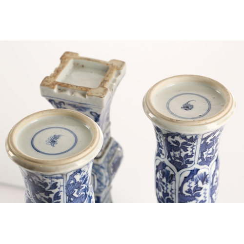 146 - A close pair of Chinese blue & white Gu vases, Qing, Kangxi period, painted with foliage in shaped p... 