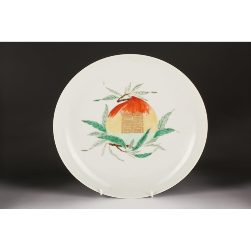 150 - A Chinese Famille Verte longevity dish, the centre painted with a peach on a leafy branch with gilt ... 