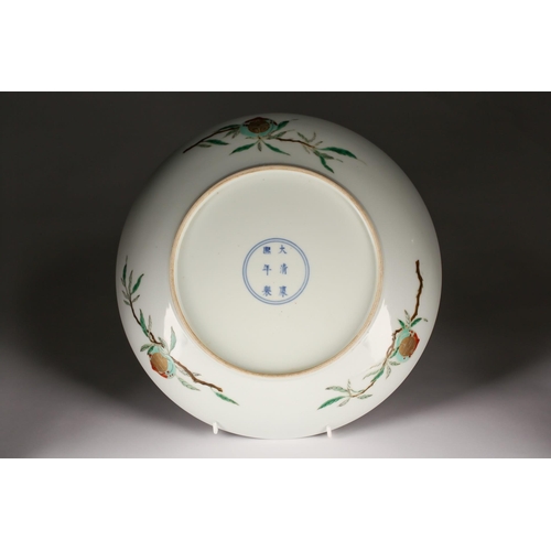 150 - A Chinese Famille Verte longevity dish, the centre painted with a peach on a leafy branch with gilt ... 