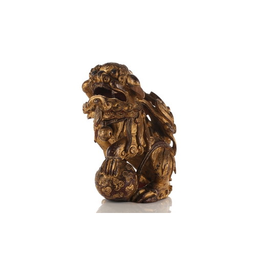 156 - A large carved and gilded wood temple lion, Qing late 19th/early 20th century, with scrolling mane a... 