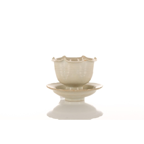 173 - A Chinese Qingbai stem cup and corresponding lobed saucer, with cream glazed, moulded petal edged bo... 