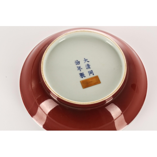 199 - A Chinese circular porcelain saucer dish with a liver red glaze to a plain body. Bearing an apocryph... 