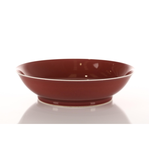 199 - A Chinese circular porcelain saucer dish with a liver red glaze to a plain body. Bearing an apocryph... 