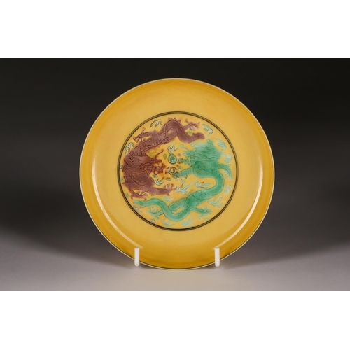 229 - A Chinese porcelain yellow grounf saucer, painted with green and aubergine dragons chasing a flaming... 