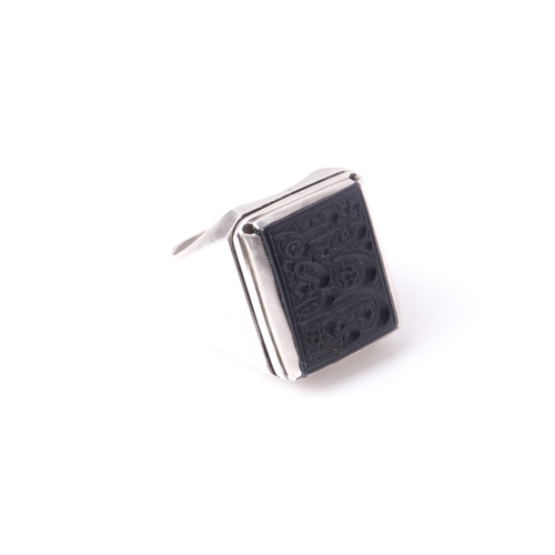 241 - An Eastern white metal and black onyx gentleman's ring, the rectangular stone with intaglio cut Isla... 