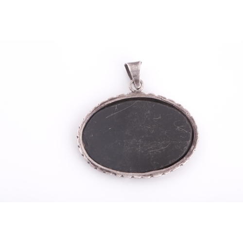 247 - A Safavid carved dark green jade pendant in silver metal mount, of oval form, engraved with calligra... 