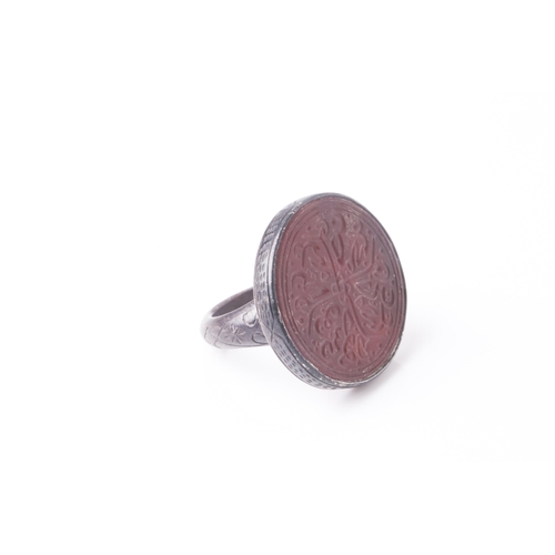 249 - A probably Persian white metal gentleman's ring set with a circular bloodstone(?) panel engraved in ... 