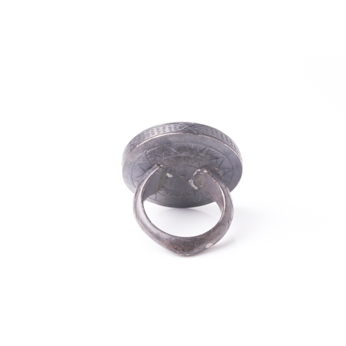 249 - A probably Persian white metal gentleman's ring set with a circular bloodstone(?) panel engraved in ... 