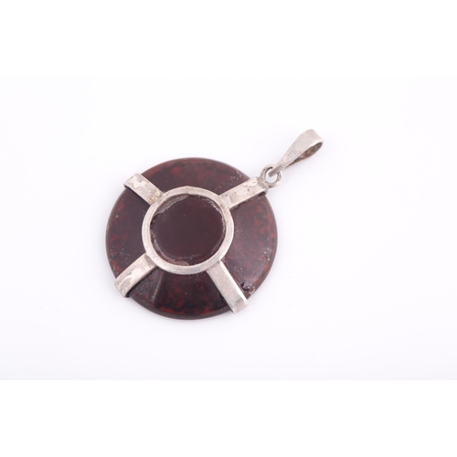 254 - An Indo Persian dark red gem pendant, engraved with calligraphy, in white metal mount.