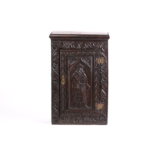 264 - An old carved oak single door wall cupboard, partly 18th century. The door is carved in relief with ... 