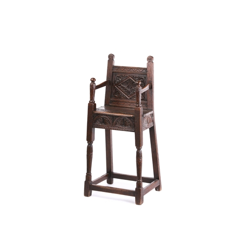 268 - A 17th-century style oak, child's joined high chair, with carved decoration, the shaped arms with tu... 