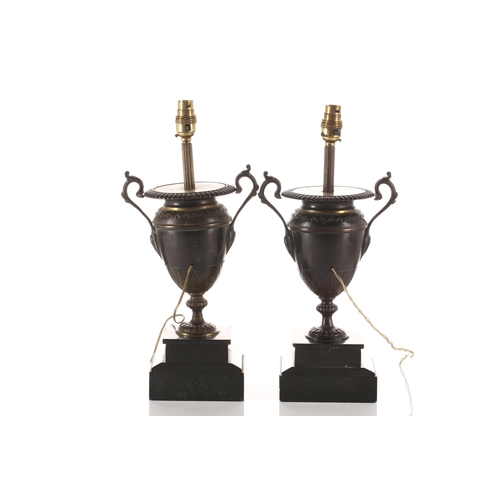 317 - A pair of patinated bronze two handle urn form table lamps, 19th century and later, with gadrooned r... 