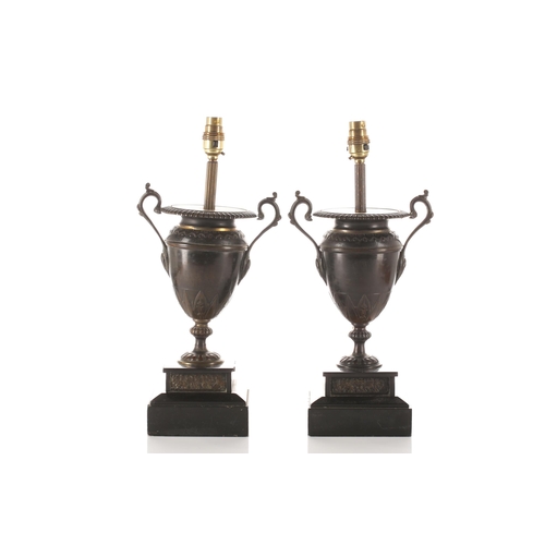 317 - A pair of patinated bronze two handle urn form table lamps, 19th century and later, with gadrooned r... 