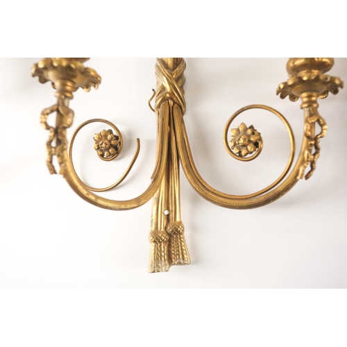 323 - A pair of Louis XVI style gilt brass wall sconces, 20th century, of tied cord form with faux hanging... 