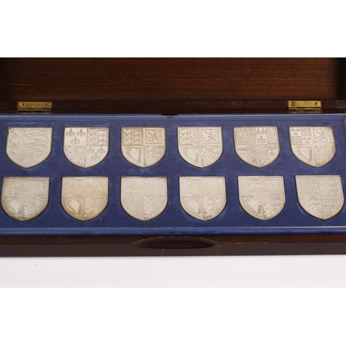 388 - The Royal Arms, a set of twelve silver shield-shaped ingots, each depicting the arms of various mona... 