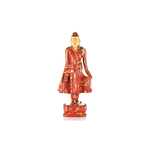 98 - A Burmese carved wood and cinnabar lacquered and parcel-gilt figure of a standing Buddha. Standing u... 