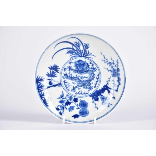 169 - A Chinese blue & white dragon saucer dish, painted with a central writhing dragon with pearl amongst... 