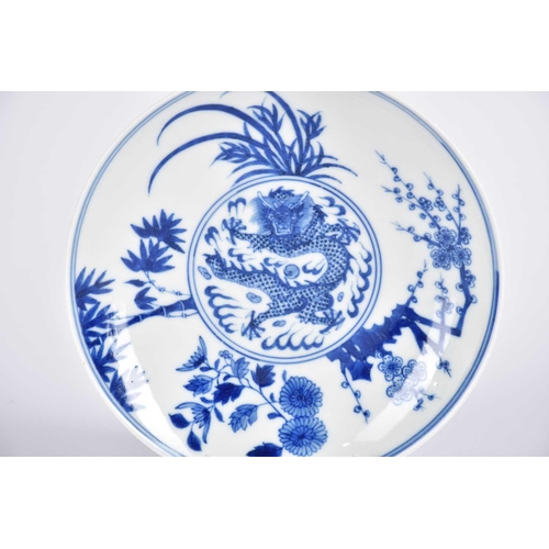 169 - A Chinese blue & white dragon saucer dish, painted with a central writhing dragon with pearl amongst... 