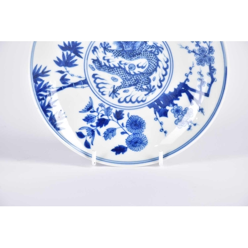 169 - A Chinese blue & white dragon saucer dish, painted with a central writhing dragon with pearl amongst... 