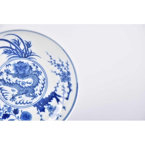 169 - A Chinese blue & white dragon saucer dish, painted with a central writhing dragon with pearl amongst... 